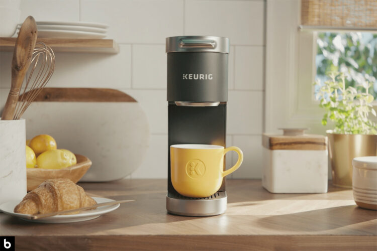 This is the cover photo for our Best Single Serve Coffee Maker article. It features a Keurig coffee maker with a light yellow cup. There a various other items on the kitchen counter, including a jar of utensils, a plate of pastries, and several plants.