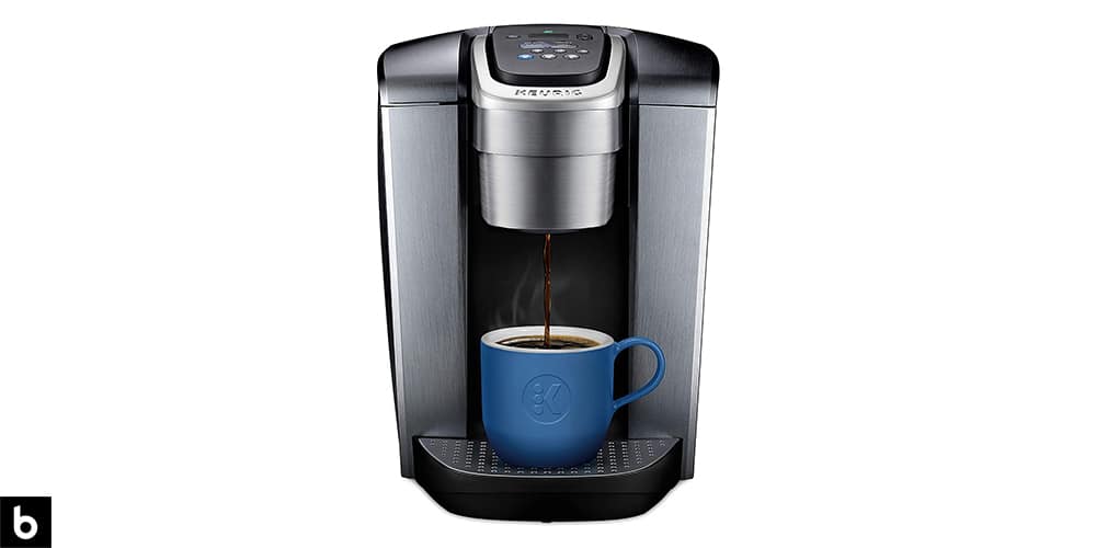 This is a photo of a metallic silver Keurig K-Elite Coffee Maker overlaid on a minimalistic white background with a Burbro logo.