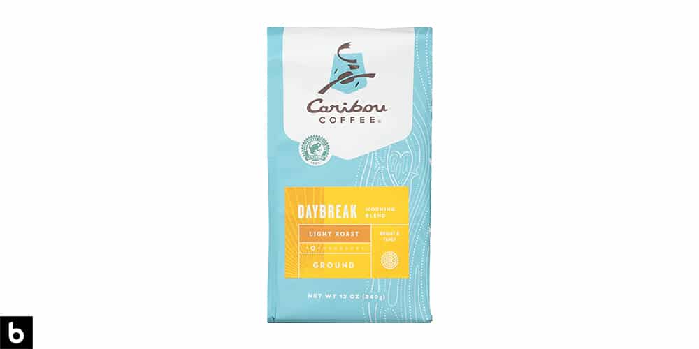 This is a product image of a blue and yellow bag of Caribou Coffee Daybreak Light Roast breakfast coffee.