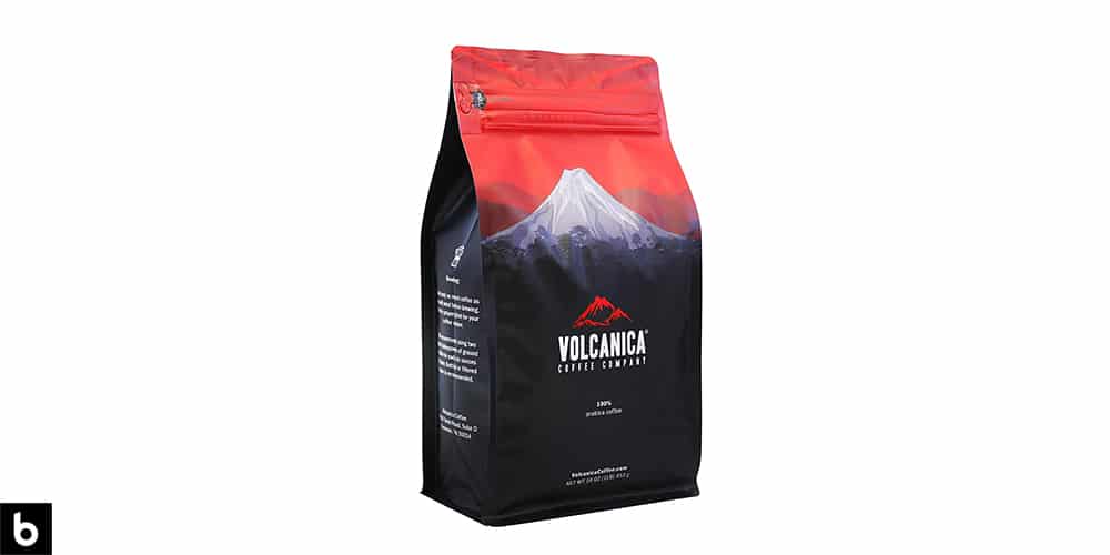 This is a product image, featuring a red and navy bag of Volcanica Organic Whole Bean Coffee. We've dubbed this one of the Best Organic Coffee Beans for French Press.