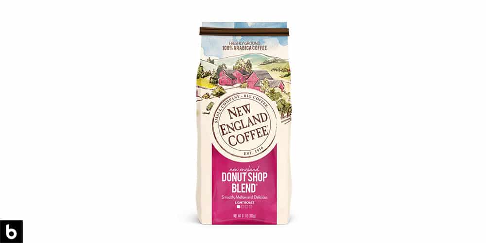 This is a product image, featuring a bag of New England Coffee Donut Shop Blend Light Roast Coffee. The bag is cream and pink colored, with a picture of a rural farm.